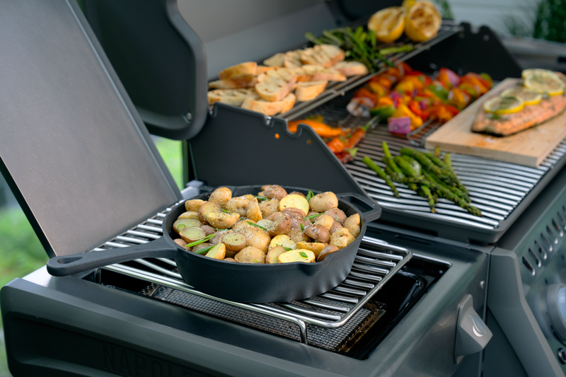 Close-up of Calidad Grills Rogue PRO 525 model grill with infrared side burner searing potatoes in a cast iron pan