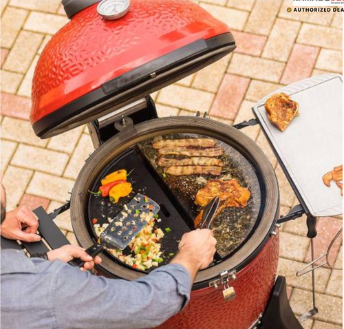 Big Joe III ceramic grill open with food cooking on 3-tier Divide and Conquer system, flames under stainless steel cooking grates and griddle accessories for North Florida